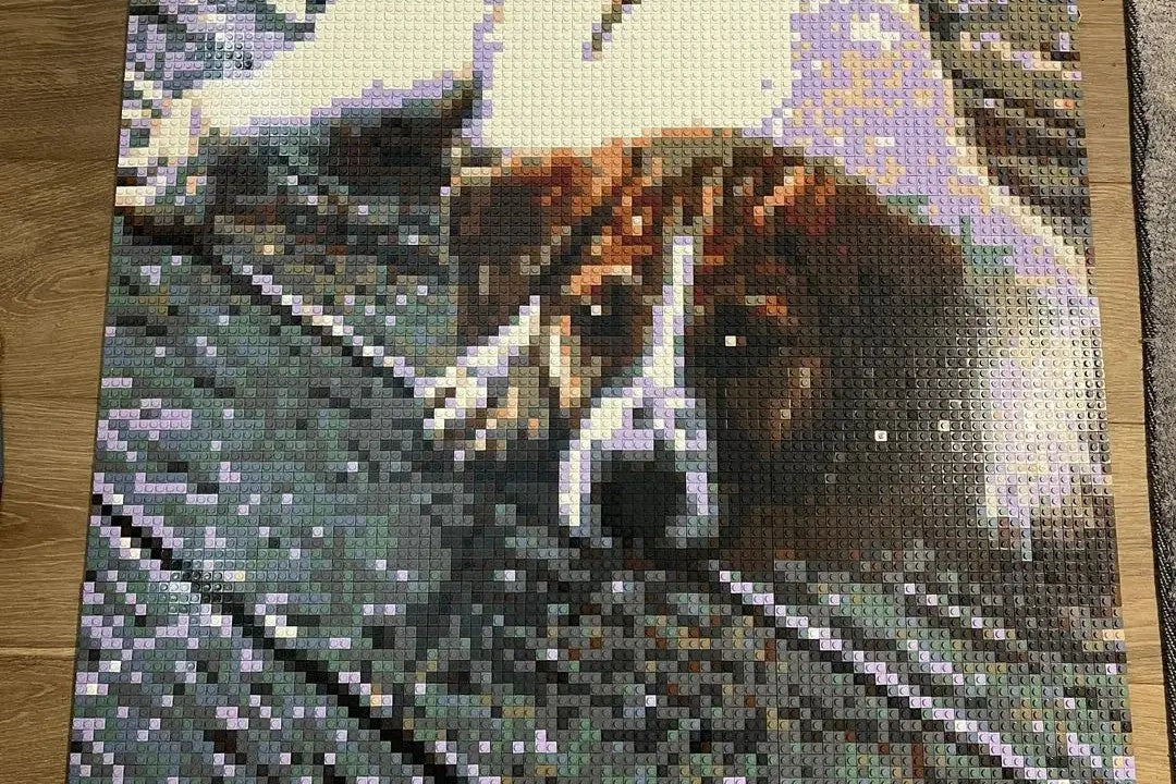 A finished brick mosaic of a resting dog, laid flat on a wooden table